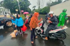 Istri wartawan yang tergabung dalam IKWI Kabupaten Tangerang bagikan takjil di tengah hujan deras di kawasan Puspemkab Tangerang di Tigaraksa, Sabtu, 8 Maret 2025.